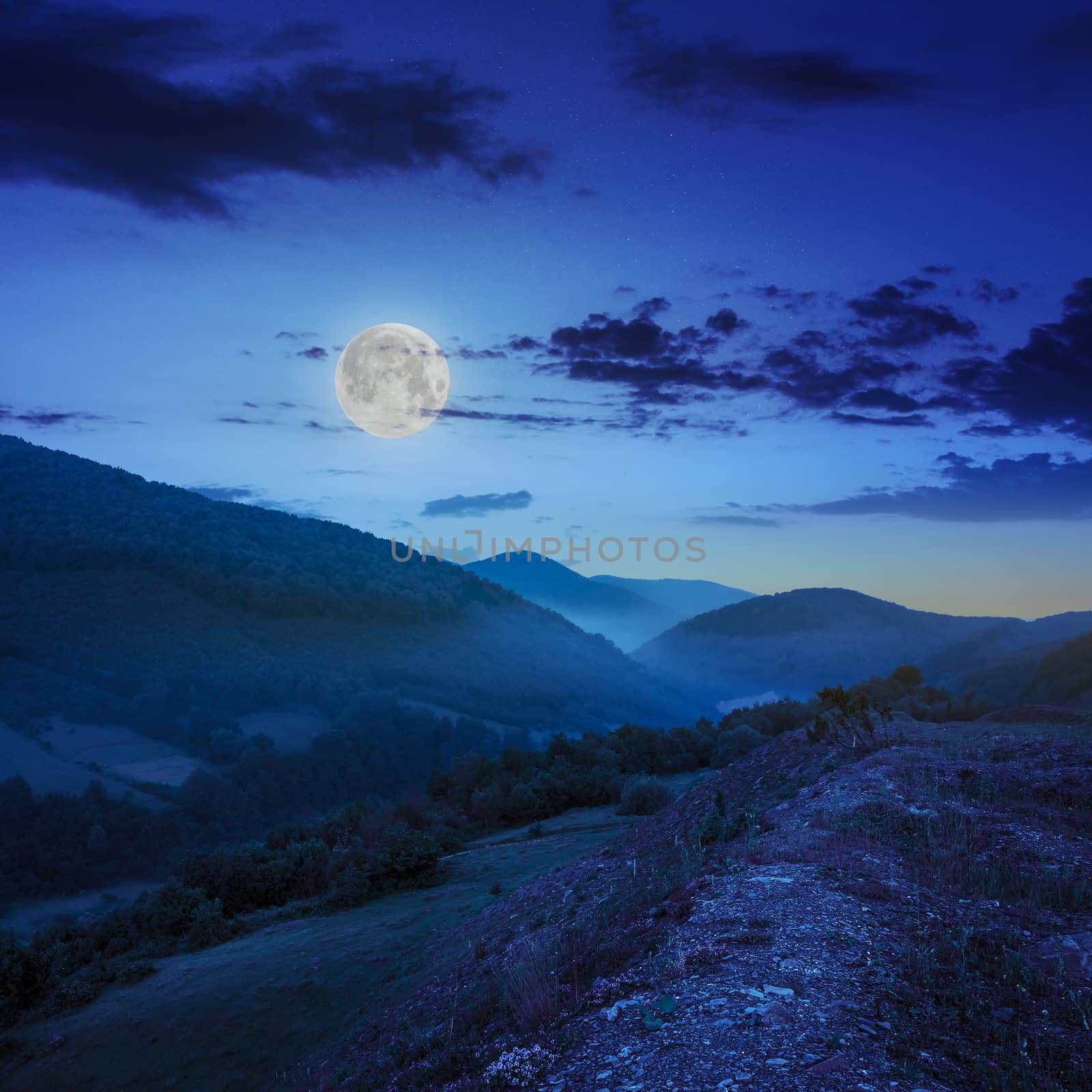 cold morning fog with red hot sunrise in the mountains at night in moon light