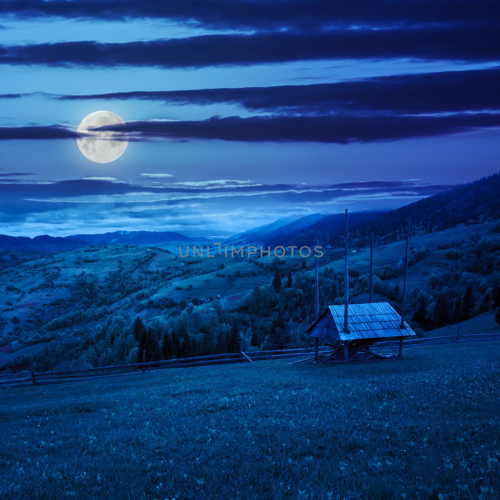 storage of firewood on hillside meadow at night by Pellinni