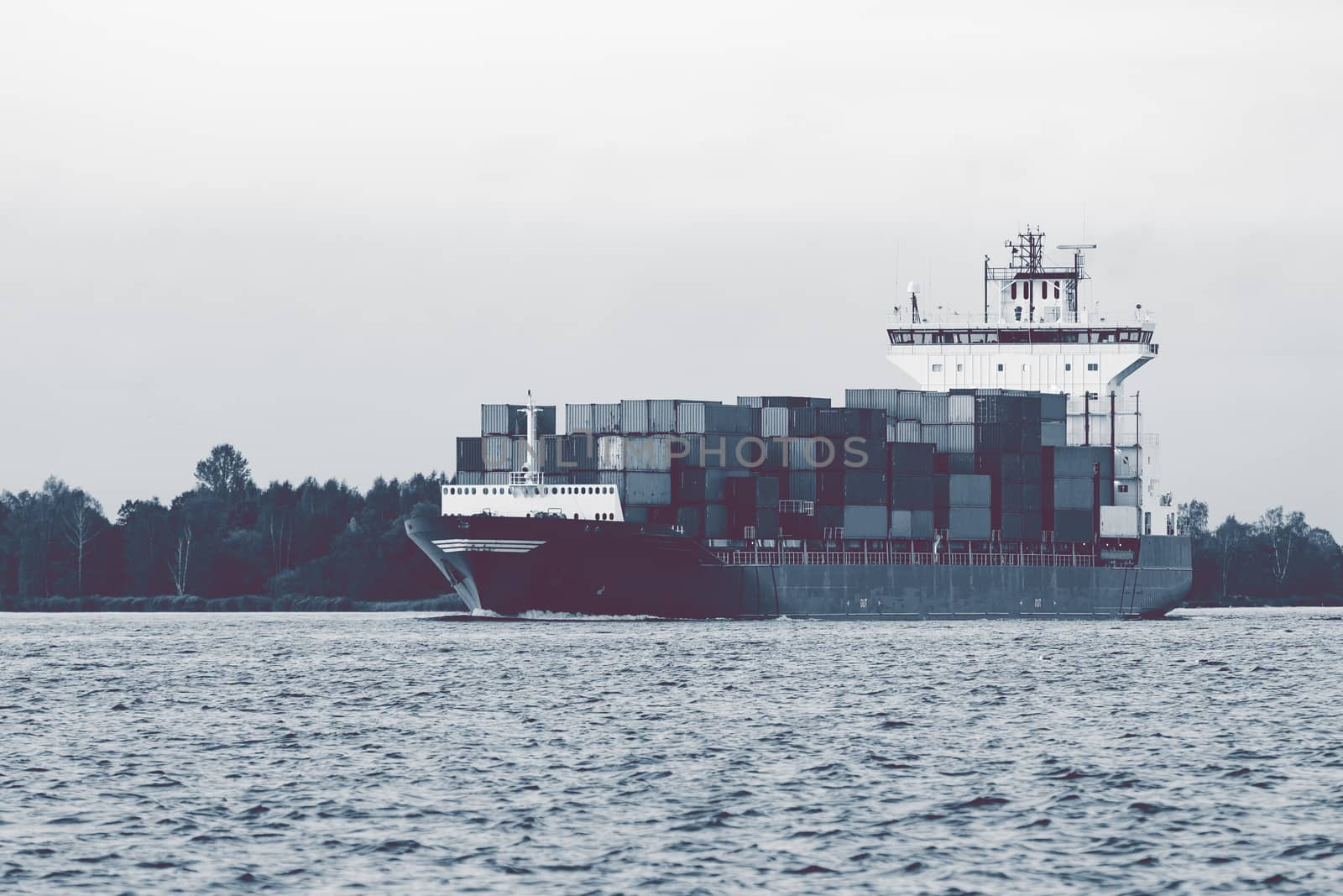 Full container ship moving to Baltic sea. Riga, Latvia