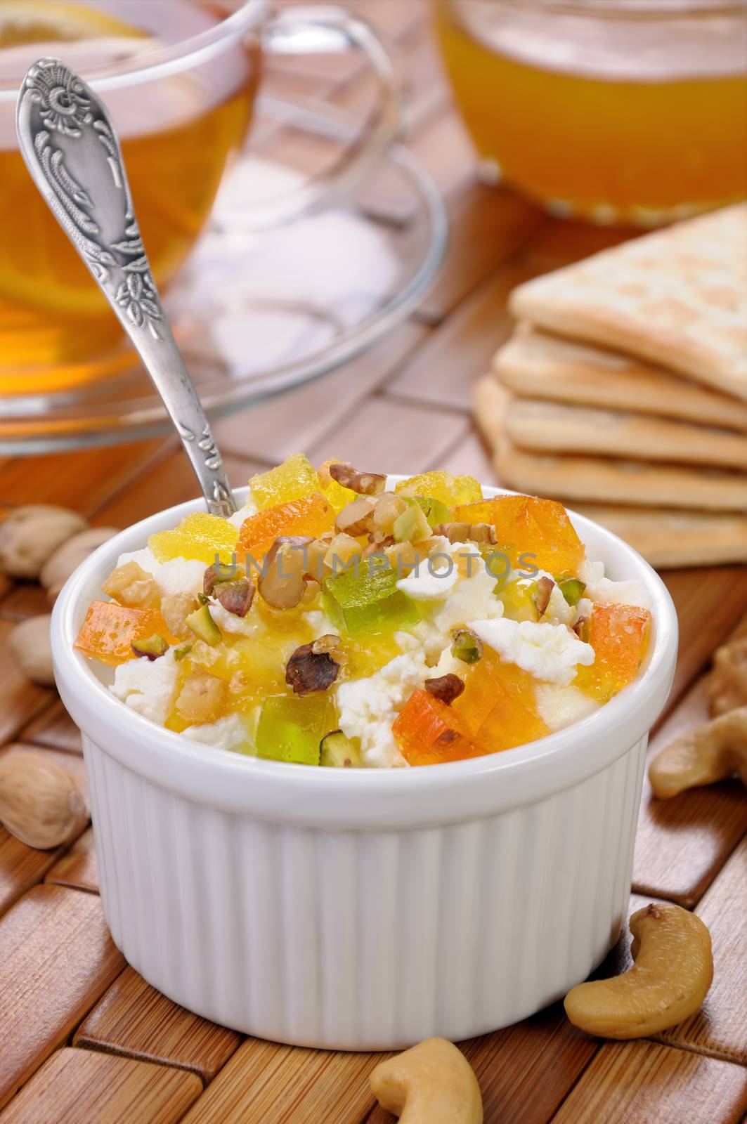 portion of cottage cheese with jam and marmalade slices, nuts, pistachios