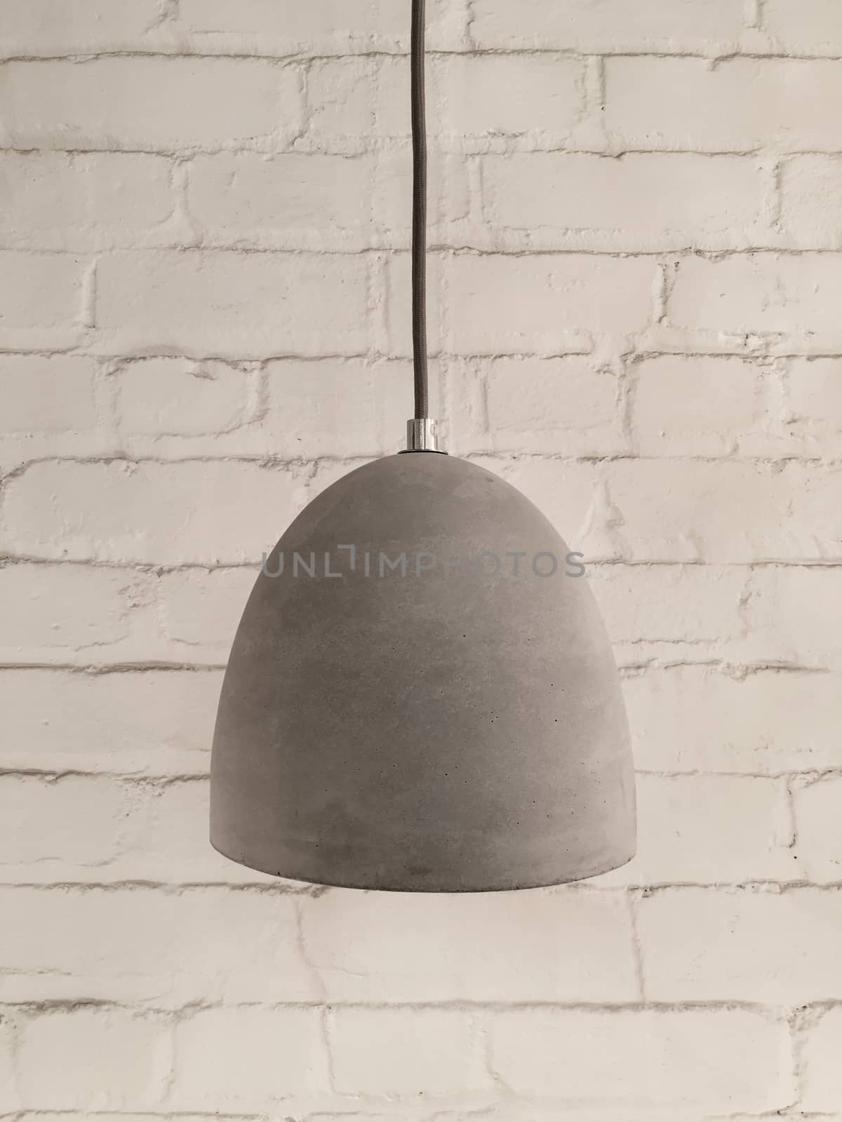 Concrete lamp on white brick background. Modern design.