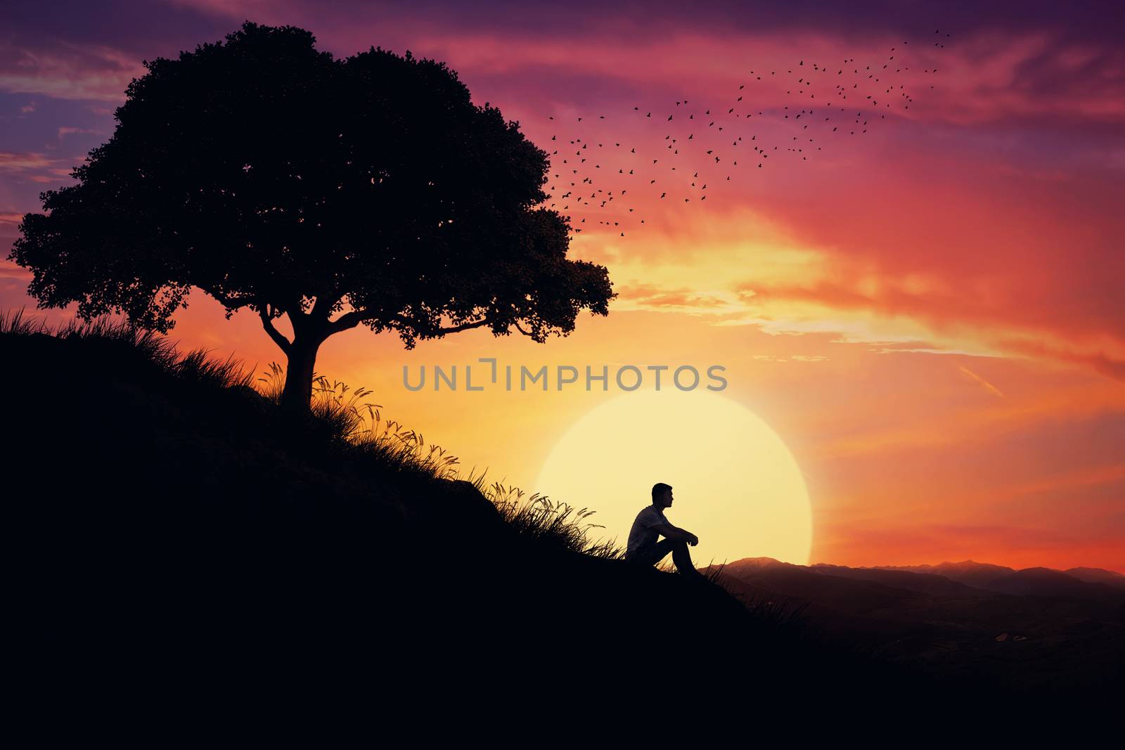 Boy sit alone on a hill in the center of nature, over a sunset background. Standing away from the crowd, waiting for the healing power of the nature.