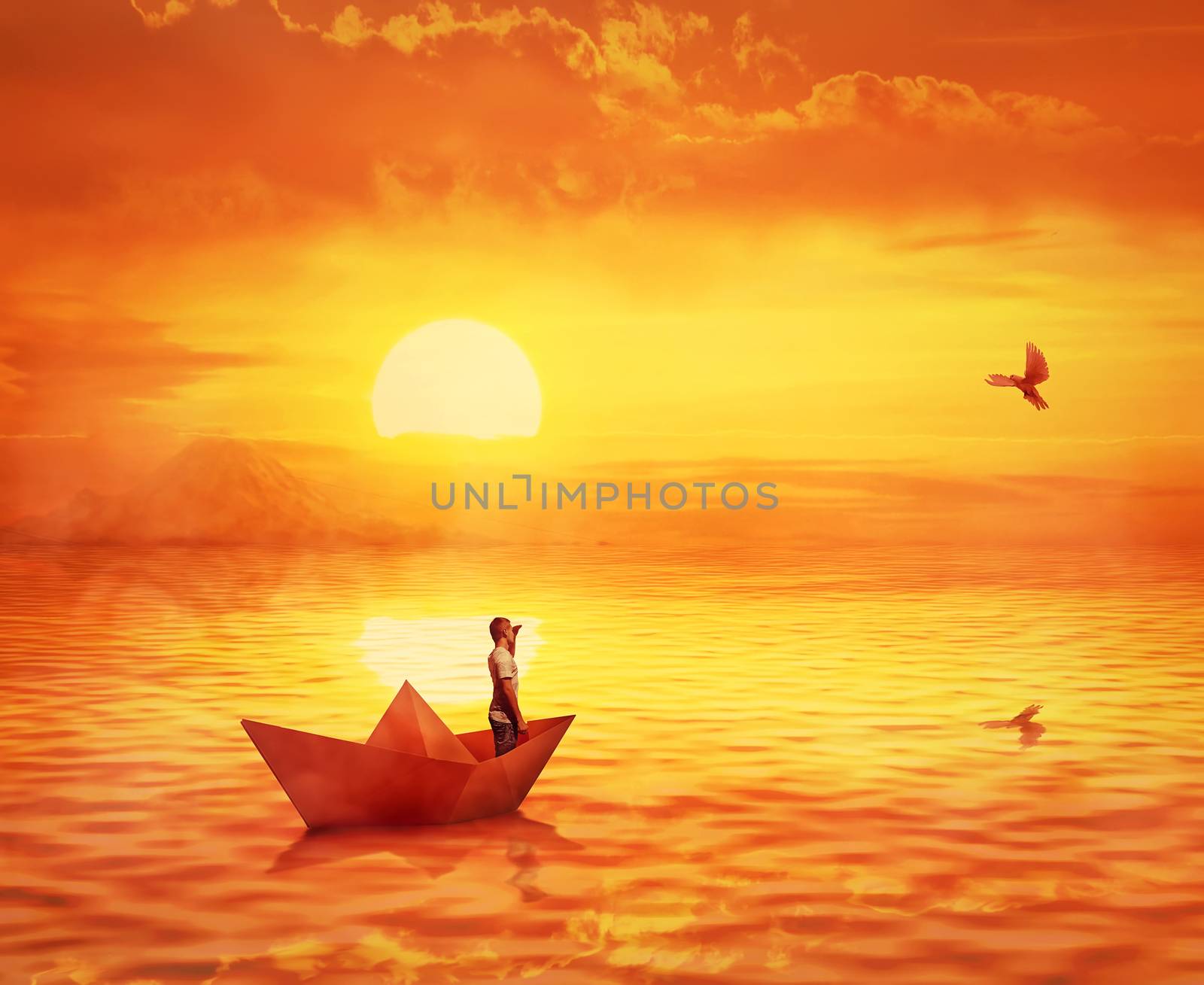 Silhouette of a lonely boy in a paper boat sailing lost in the ocean, against orange sunset sky and a pigeon flying to find the shore. Adventure and journey concept, searching for help.