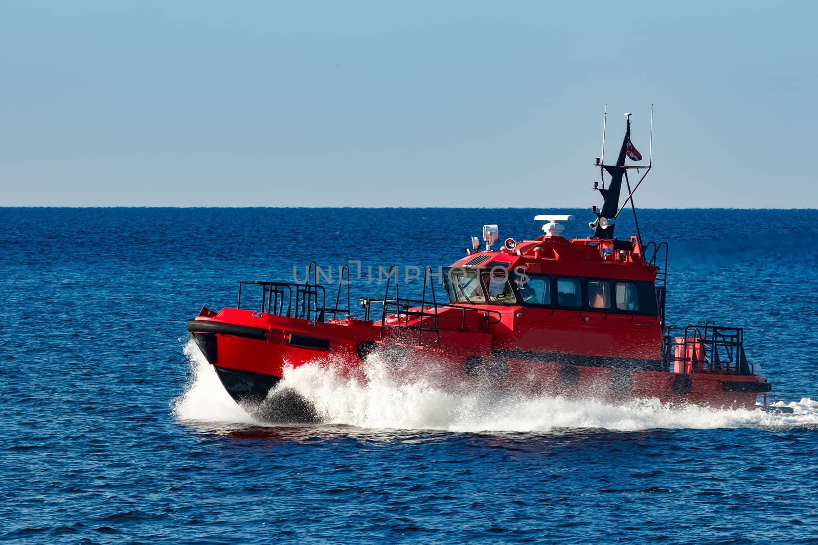 Red pilot ship moving from the Baltic sea