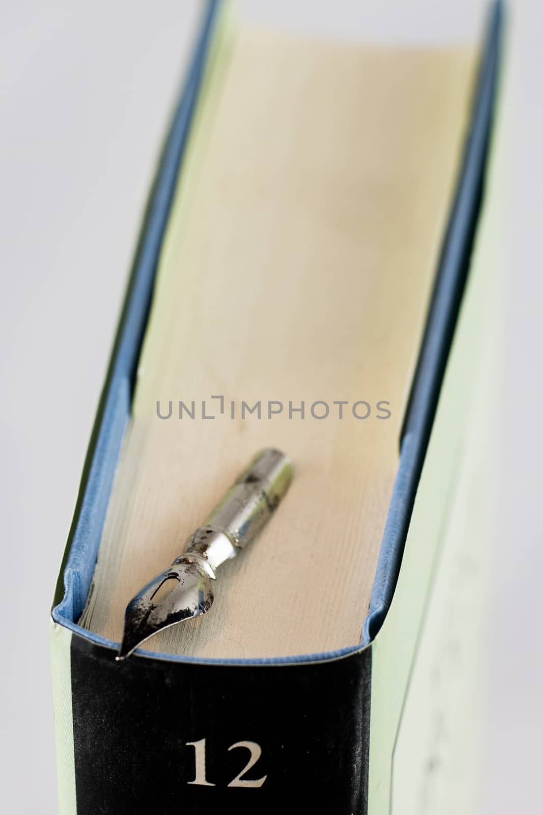 Heap of books on a white isolated background with a nib