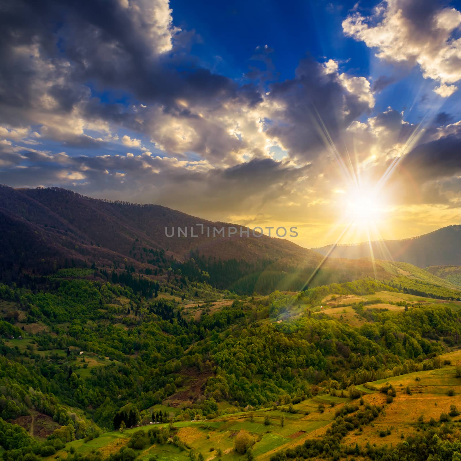 autumn landscape. village on the hillside. forest on the mountain light fall on clearing on mountains at sunset