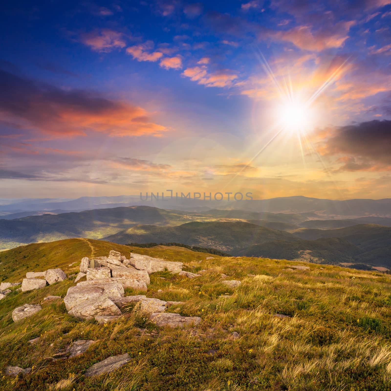 white sharp stones on the hillside on top of mountain range at sunset