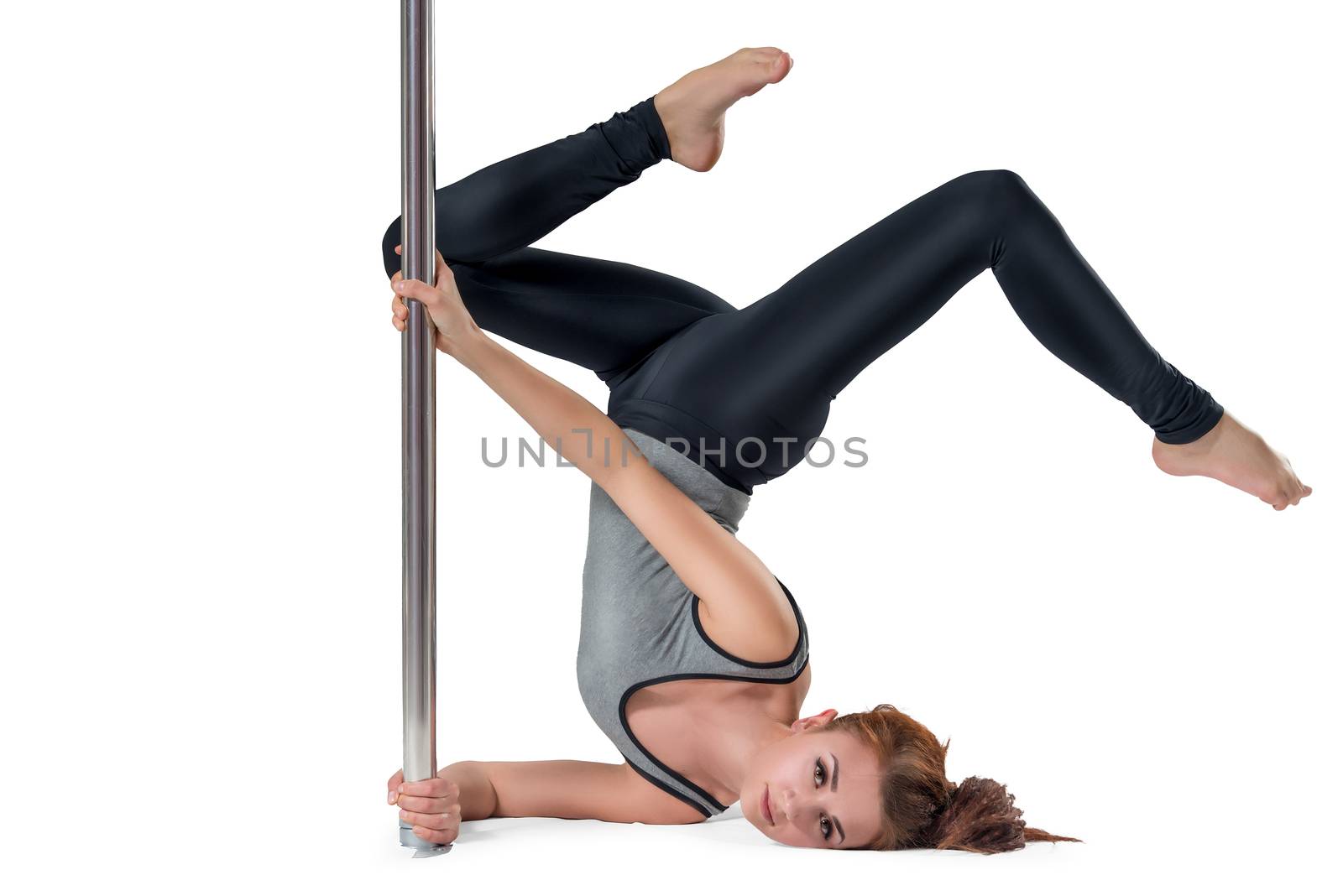 Brunette sportswoman doing stretching near pylon on white background