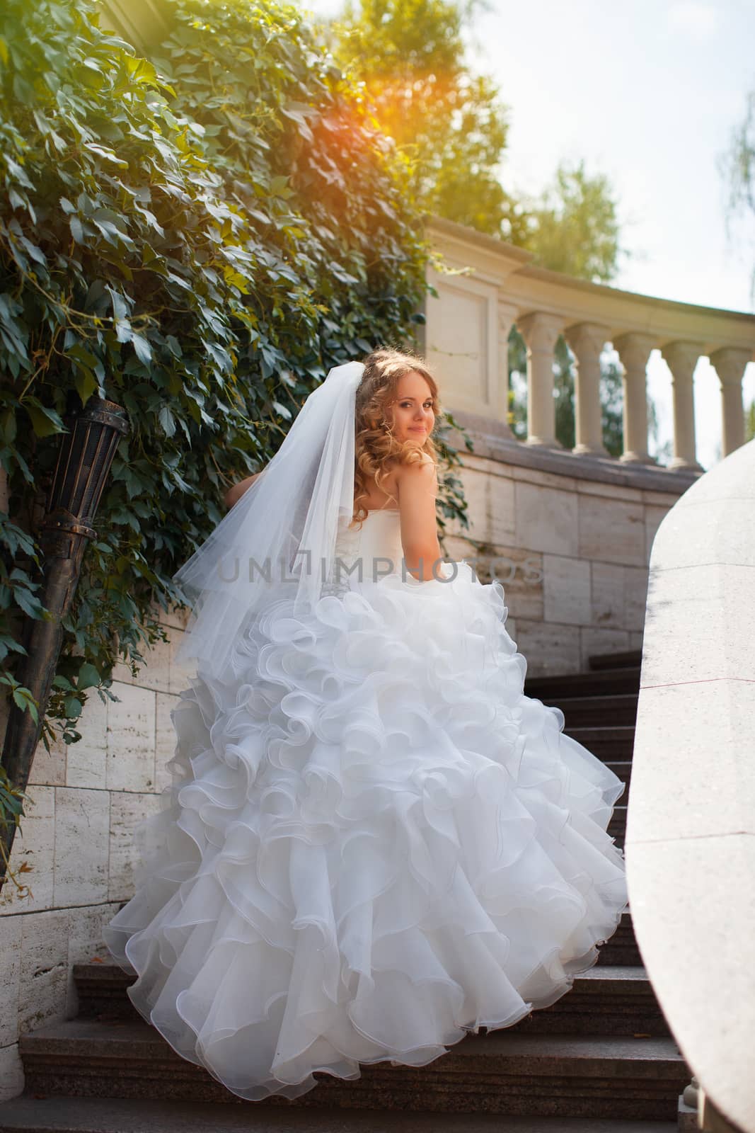 Stylish bride in a white dress in the countryside