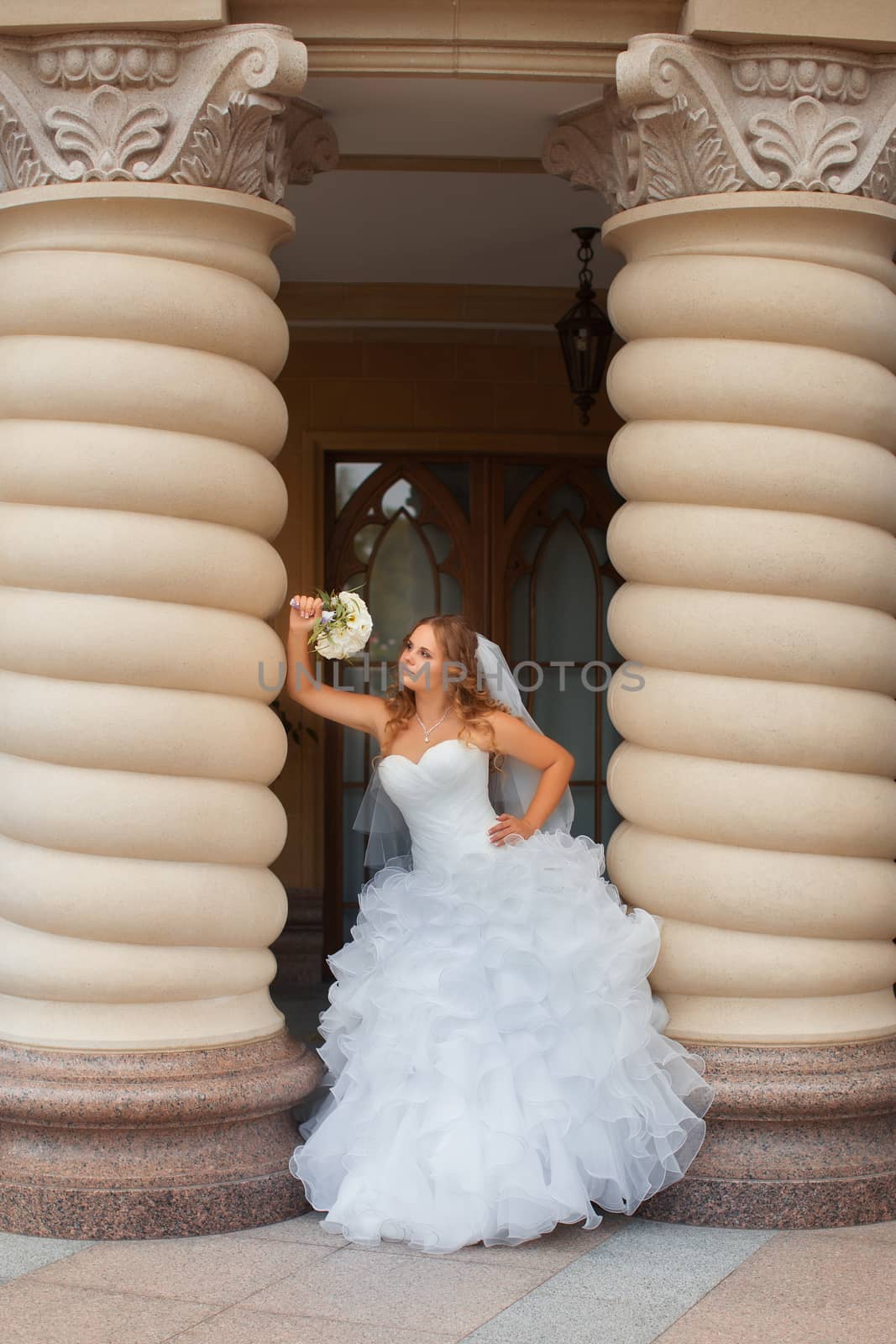 Stylish bride in a white dress in the countryside