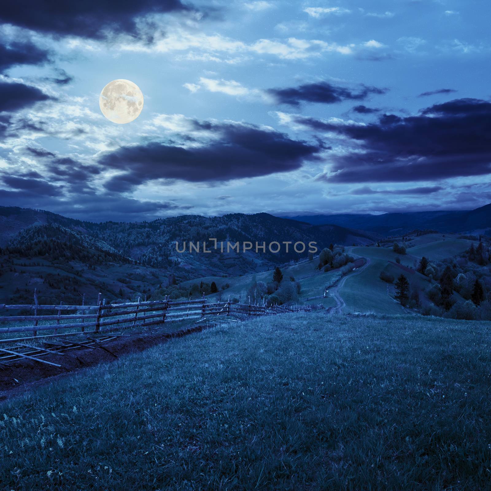 fence on hillside meadow in mountain at night by Pellinni