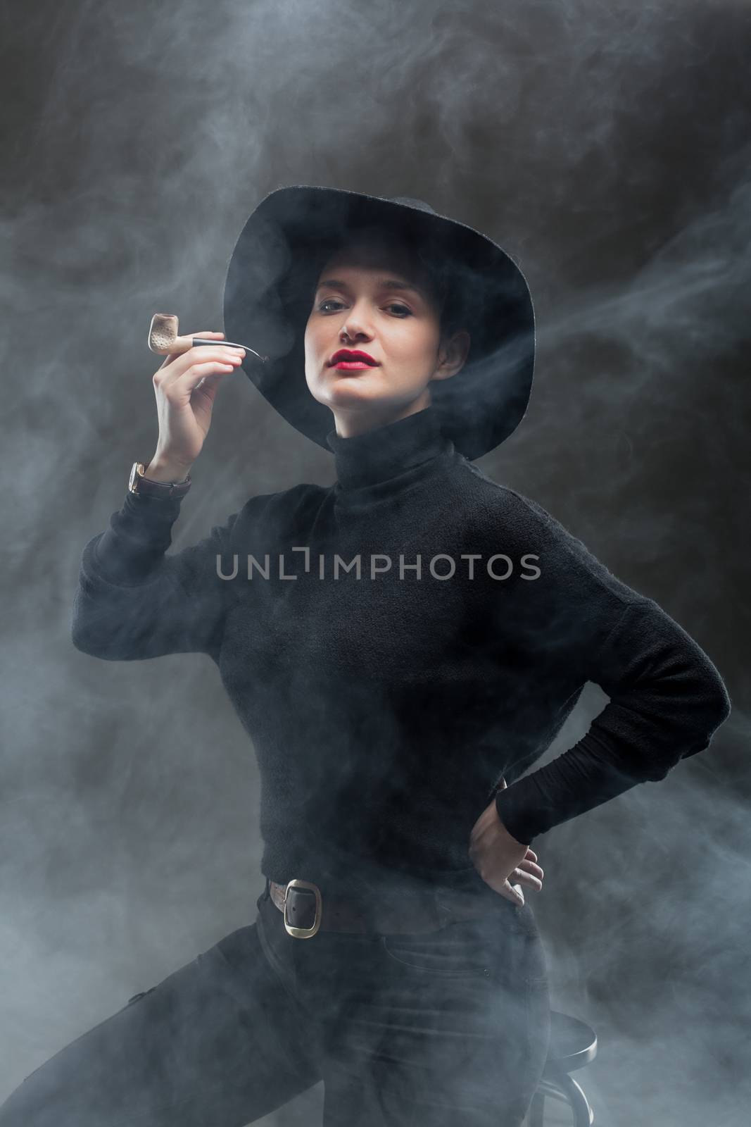 girl in black holding a pipe on smoke background