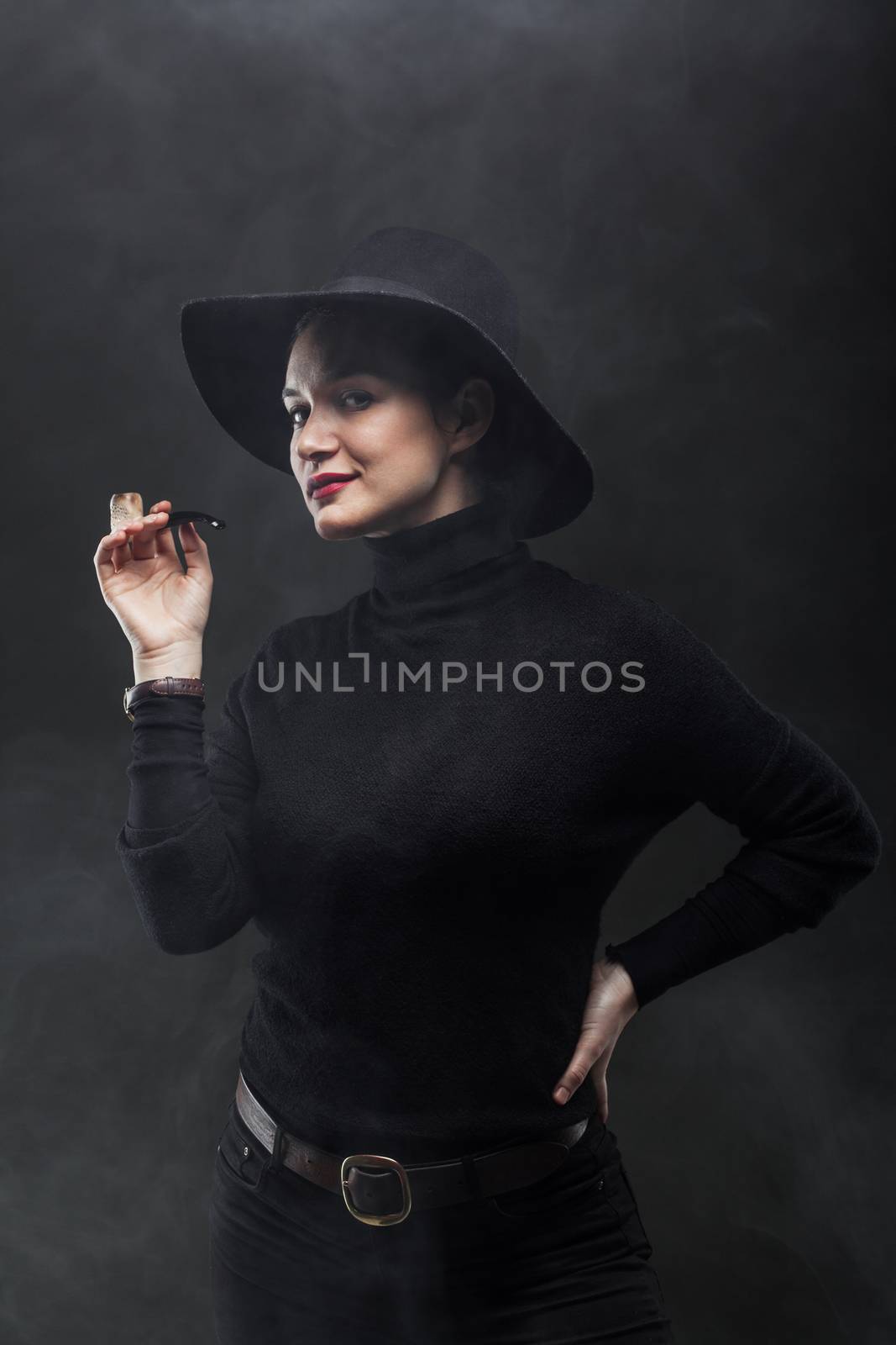 girl in black holding a pipe on smoke background