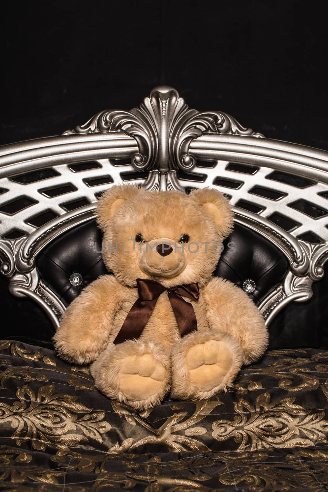 Teddy bear sits on a steel chair