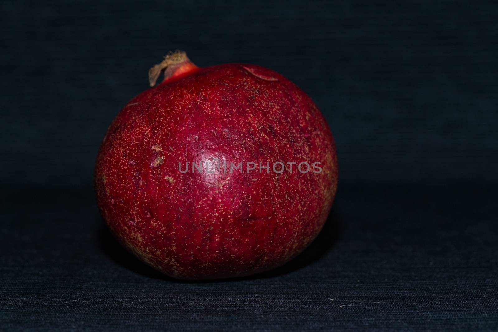 Red pomegranate on a black background close up