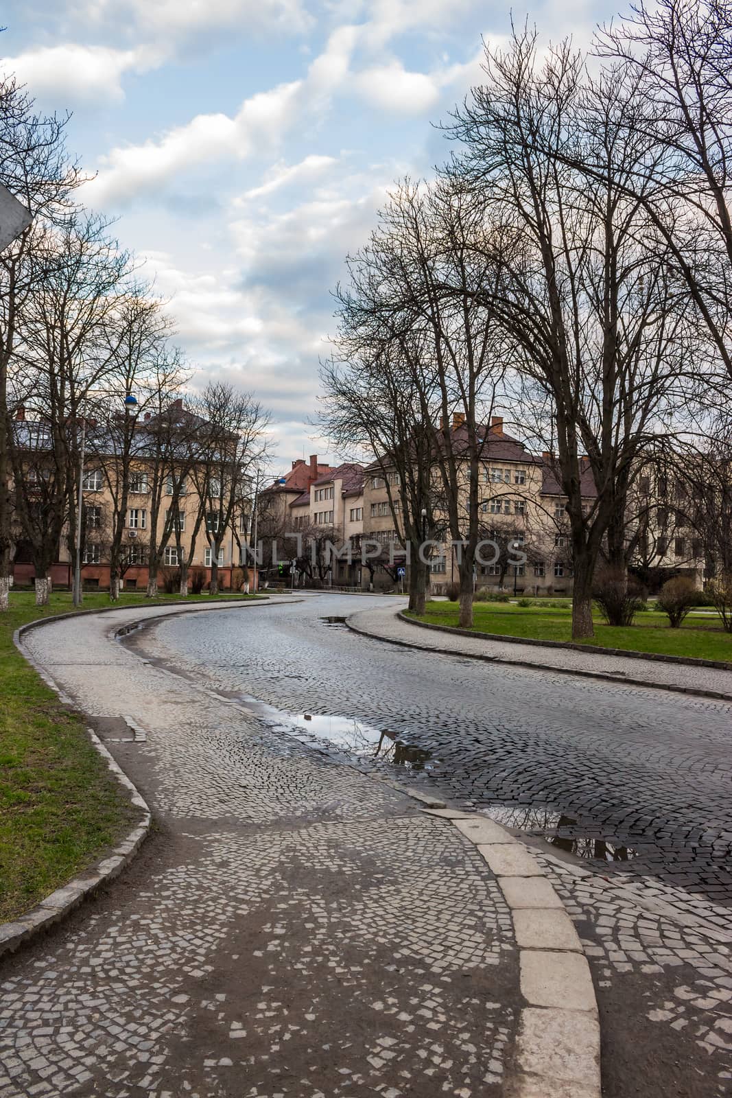 paving street winds through the old town near the park in the early autumn morning