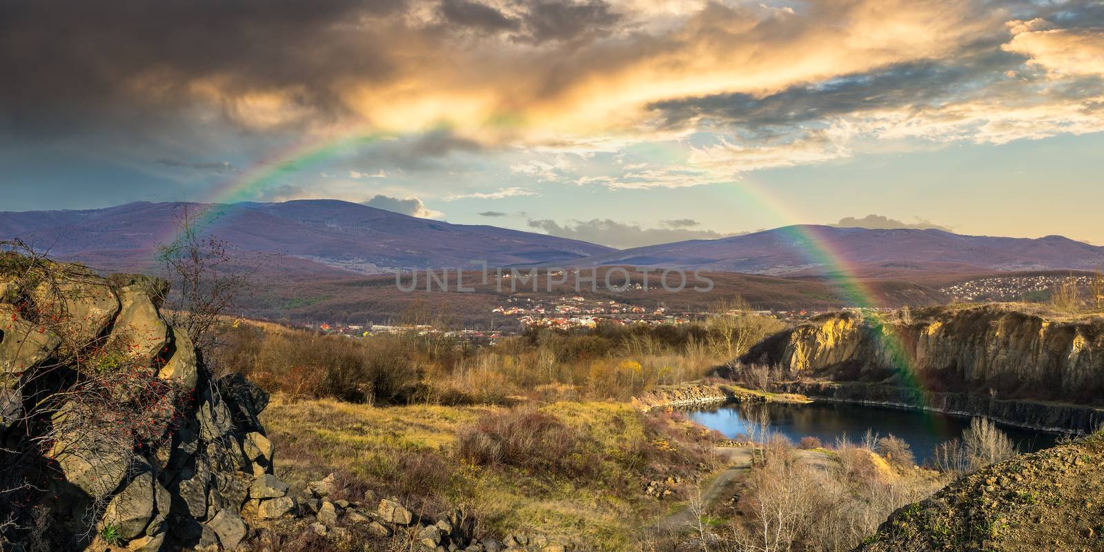 lake in mountains quarry near city with rainbow by Pellinni