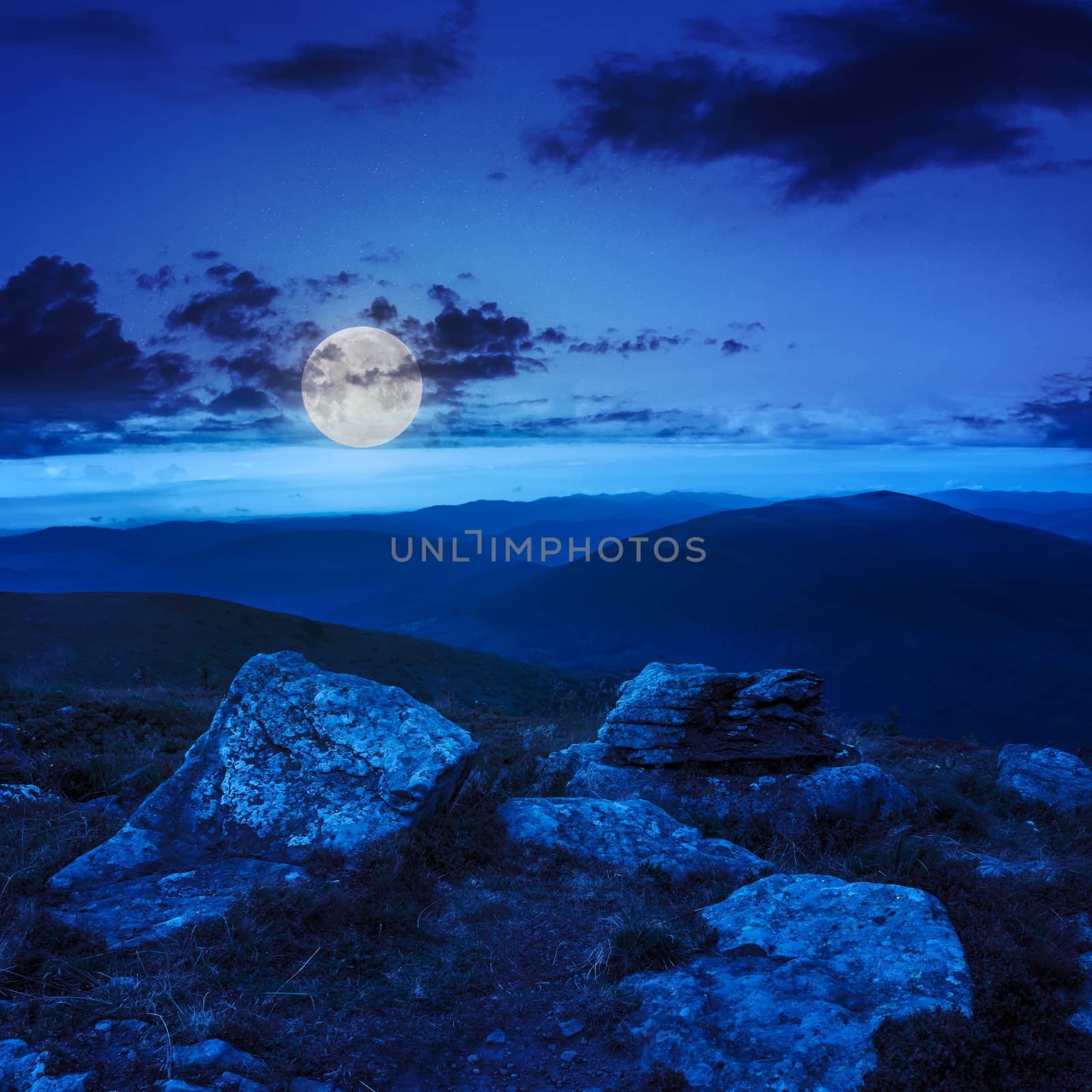 white sharp stones on the hillside at night in moon mlight