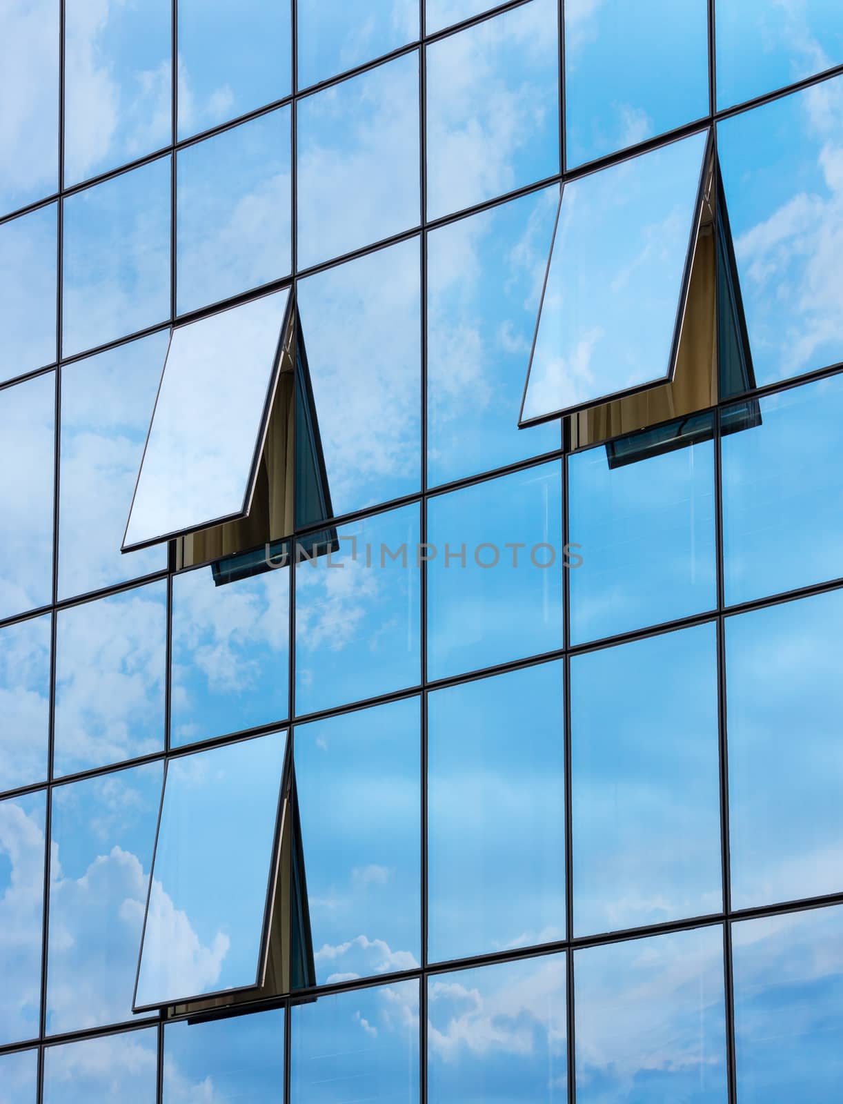 wall glass skyscraper with reflection of the sky and the three open windows 