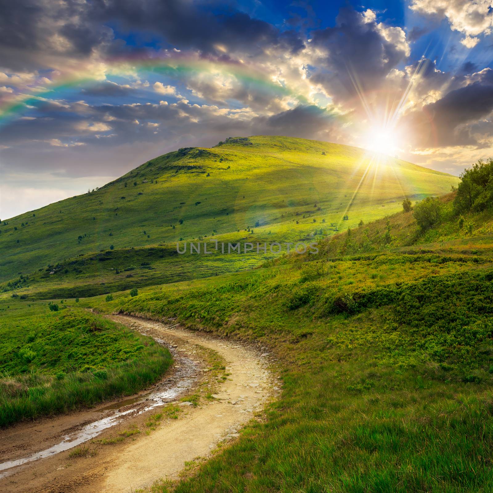 mountain path uphill to the sky at sunset with rainbow by Pellinni