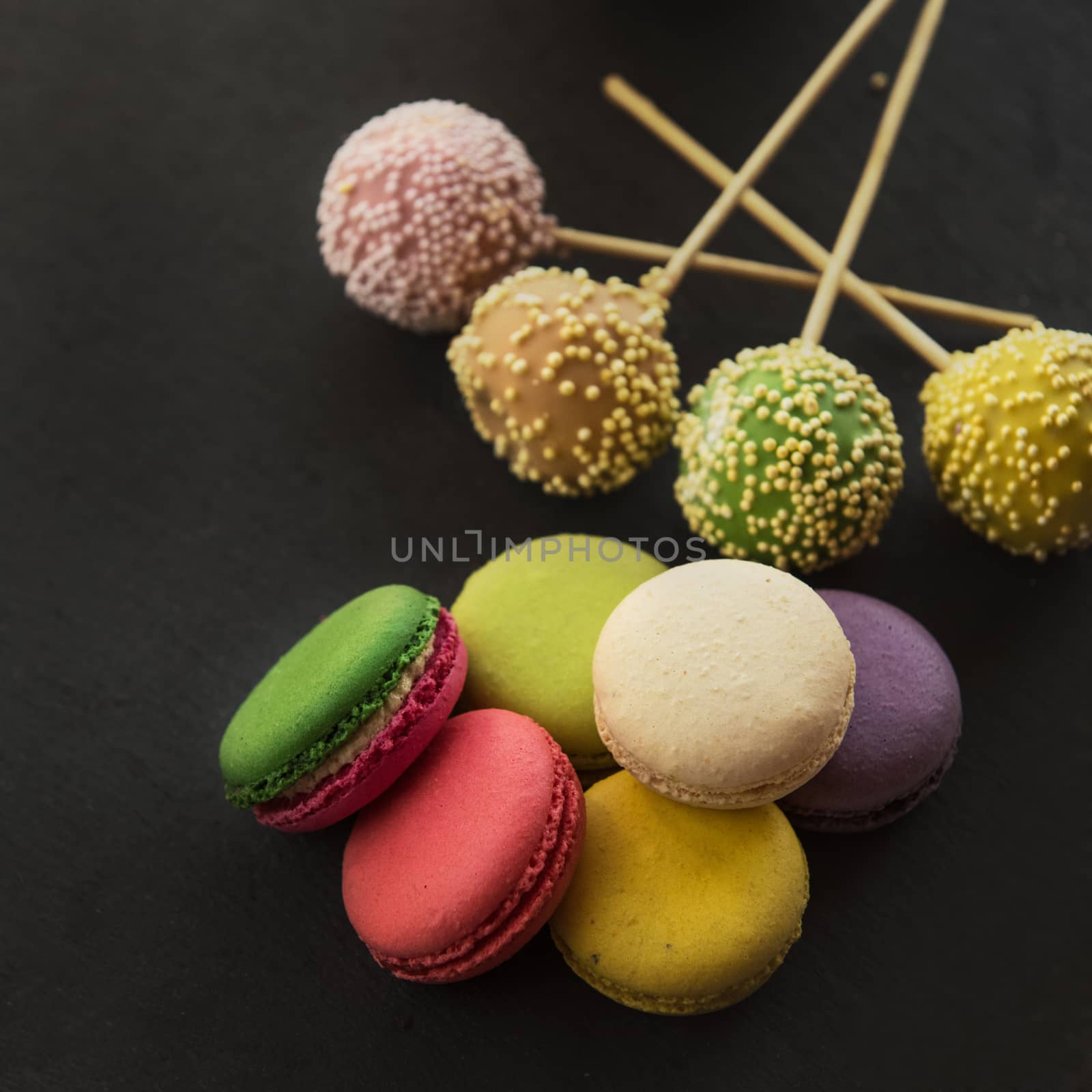 French colorful macarons on black background