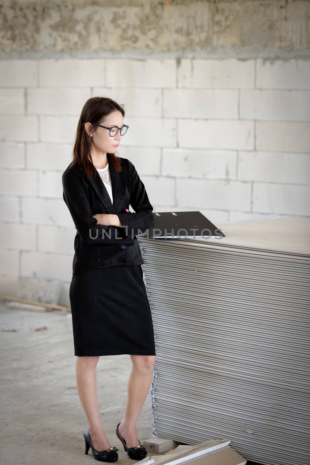 Business woman standing thoughtful in a building.