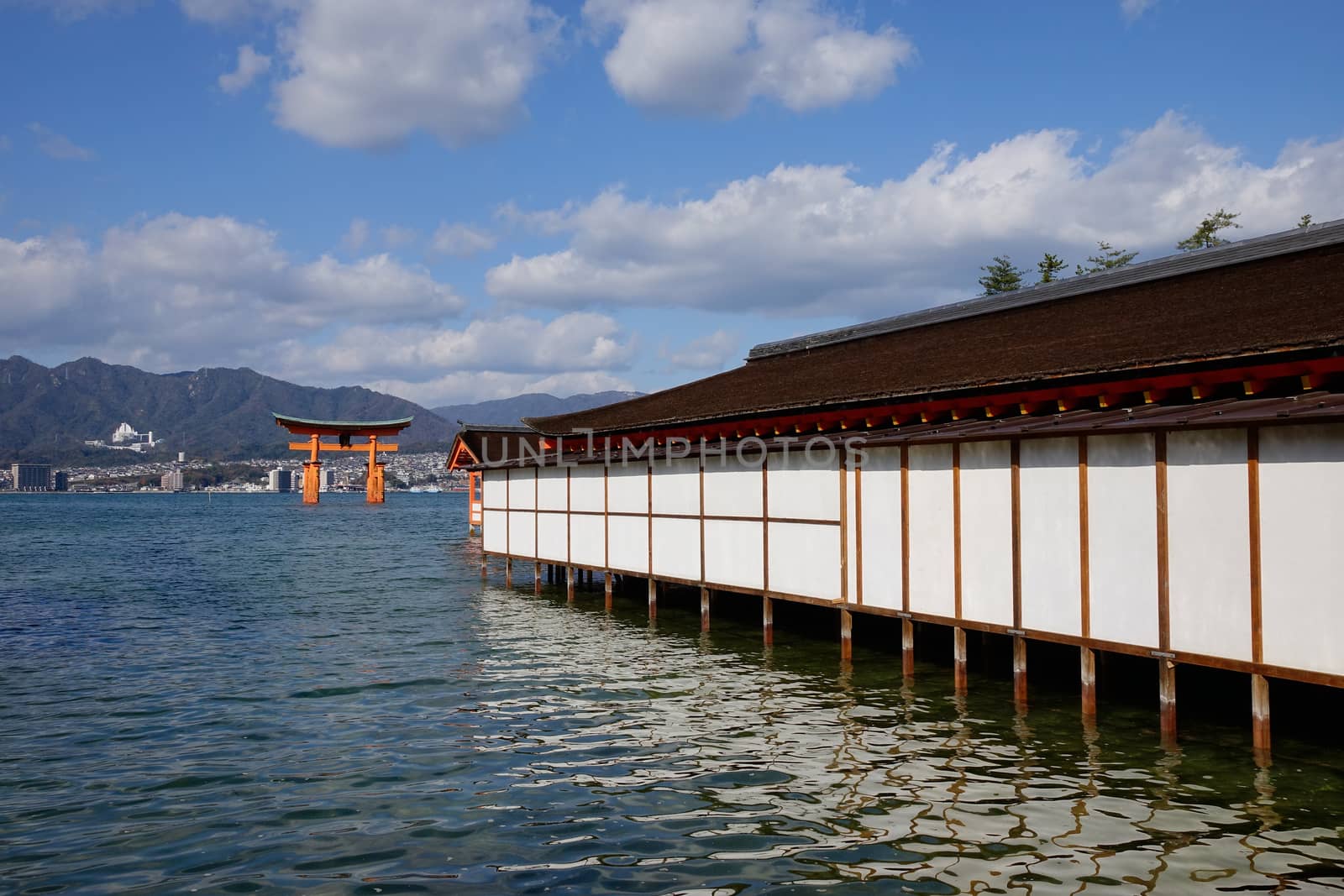 Itsukushima Shrine with Giant Torii on the island in Hiroshima, Japan. The historic shrine complex is listed as a UNESCO World Heritage Site.