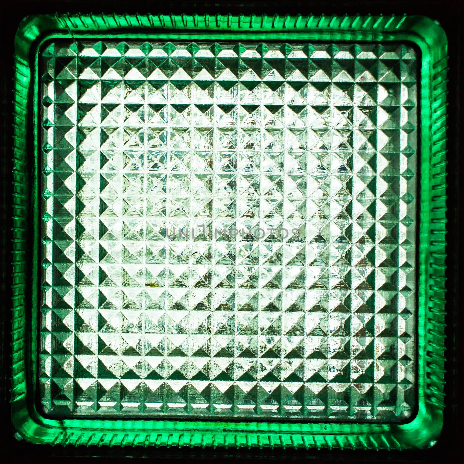 Square green glass block. Transparent building material. Element of the glass wall. Texture or background.