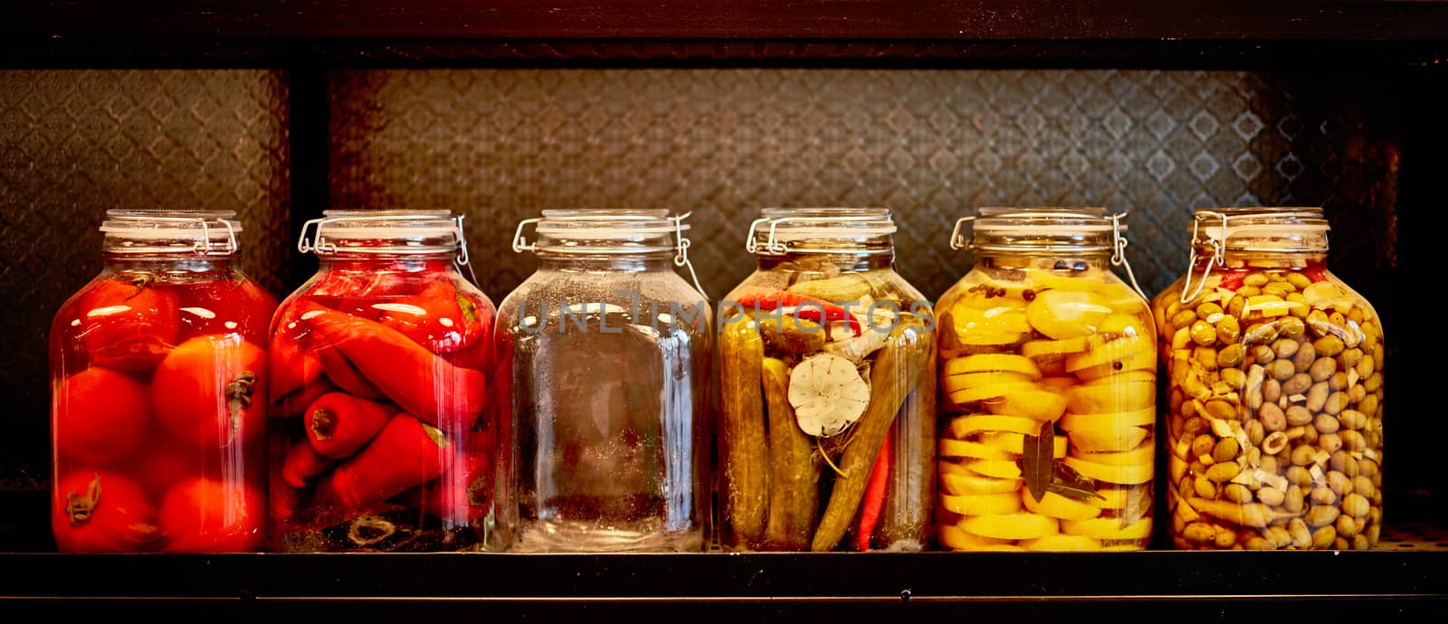 Jars with pickles in a food place, black background