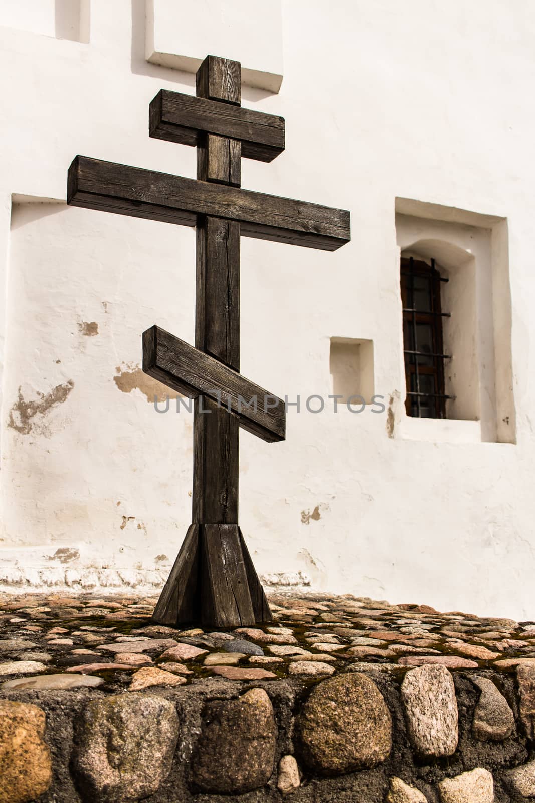 Wooden cross next to the wall of the orthodox church. by taras_chernenko