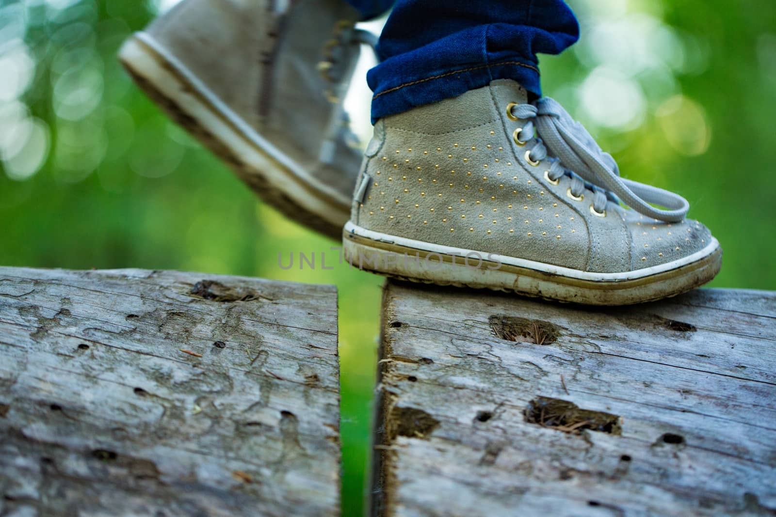 Feet close up on a log against a forest background. by boys1983@mail.ru