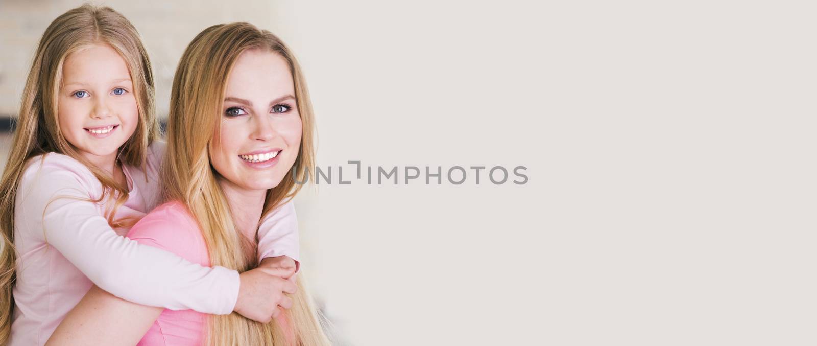 Portrait of beautiful young mother and daughter piggyback ride, photo with copy space