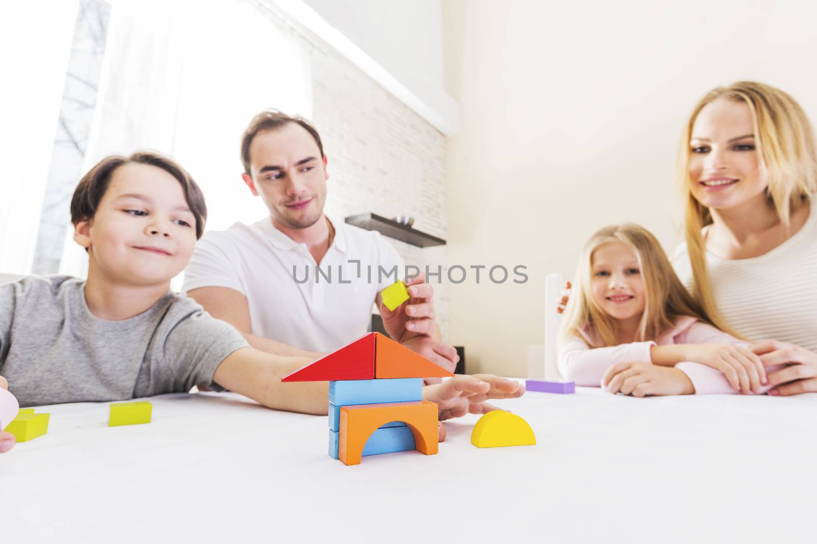 Family with children constructing house by Yellowj