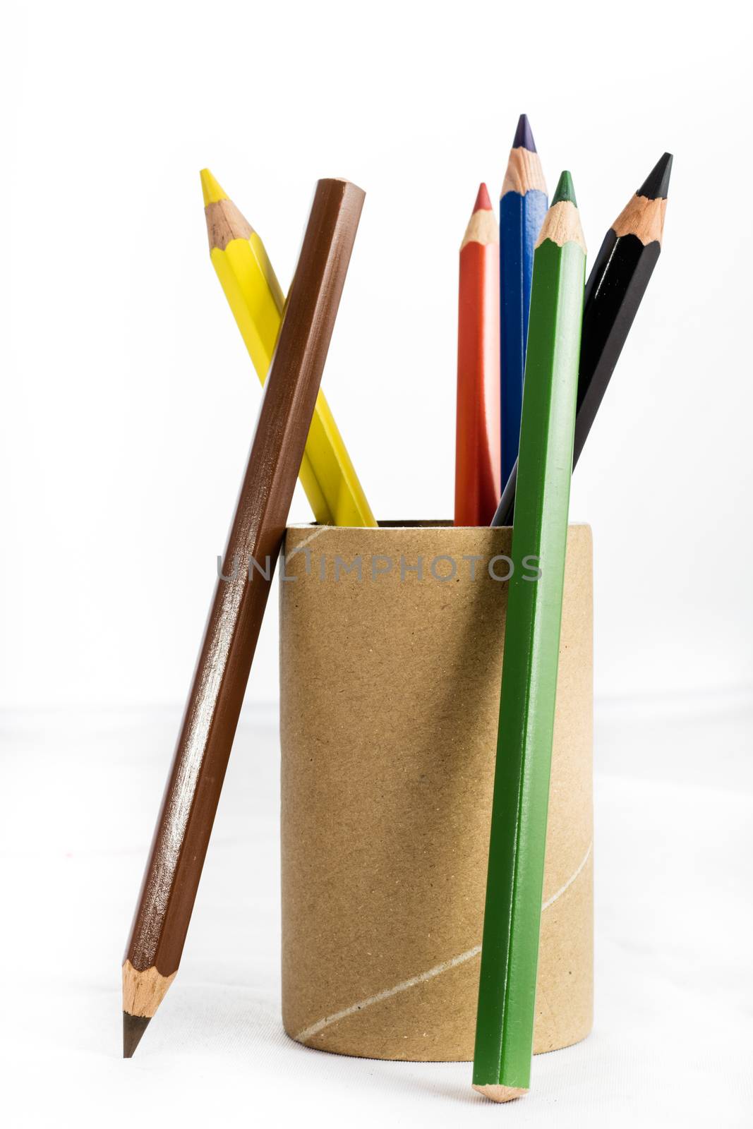 Colorful baby crayons in a cup on a white background