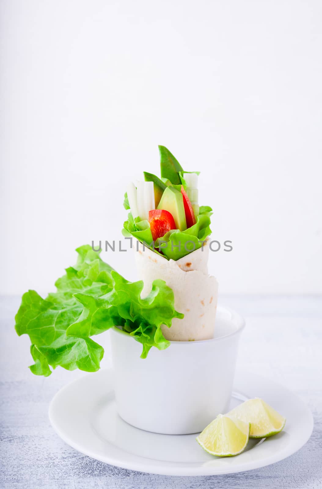 Vegetable wrap sandwiches with greenery on a white plate