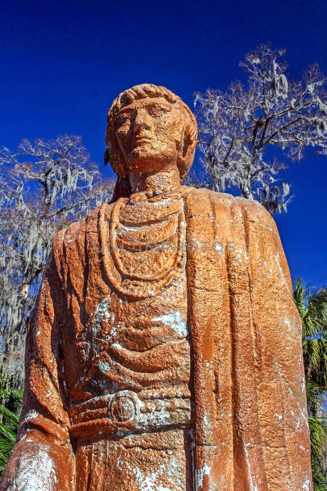 An orange / brown colored statue with blue sky