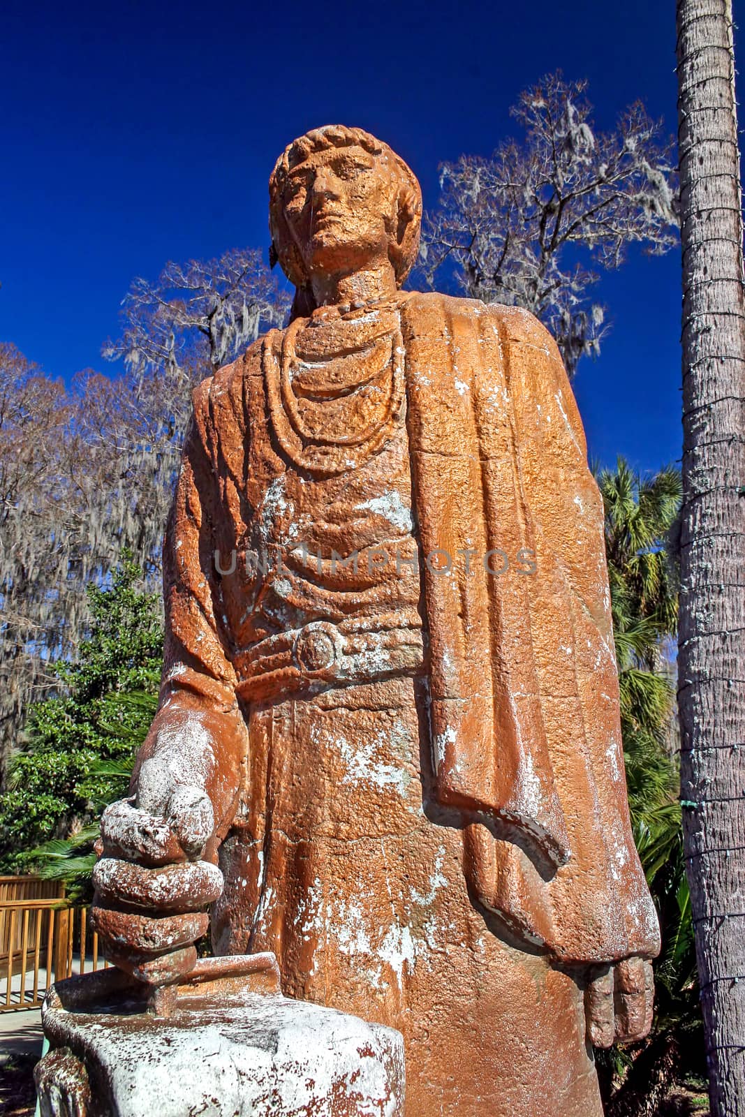 An orange / brown colored statue with blue sky