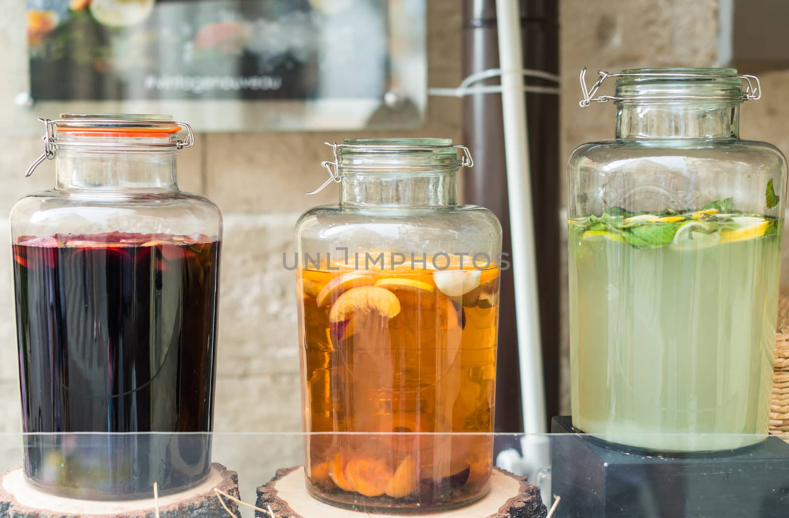 glass jars filled juices on wooden stumps by okskukuruza