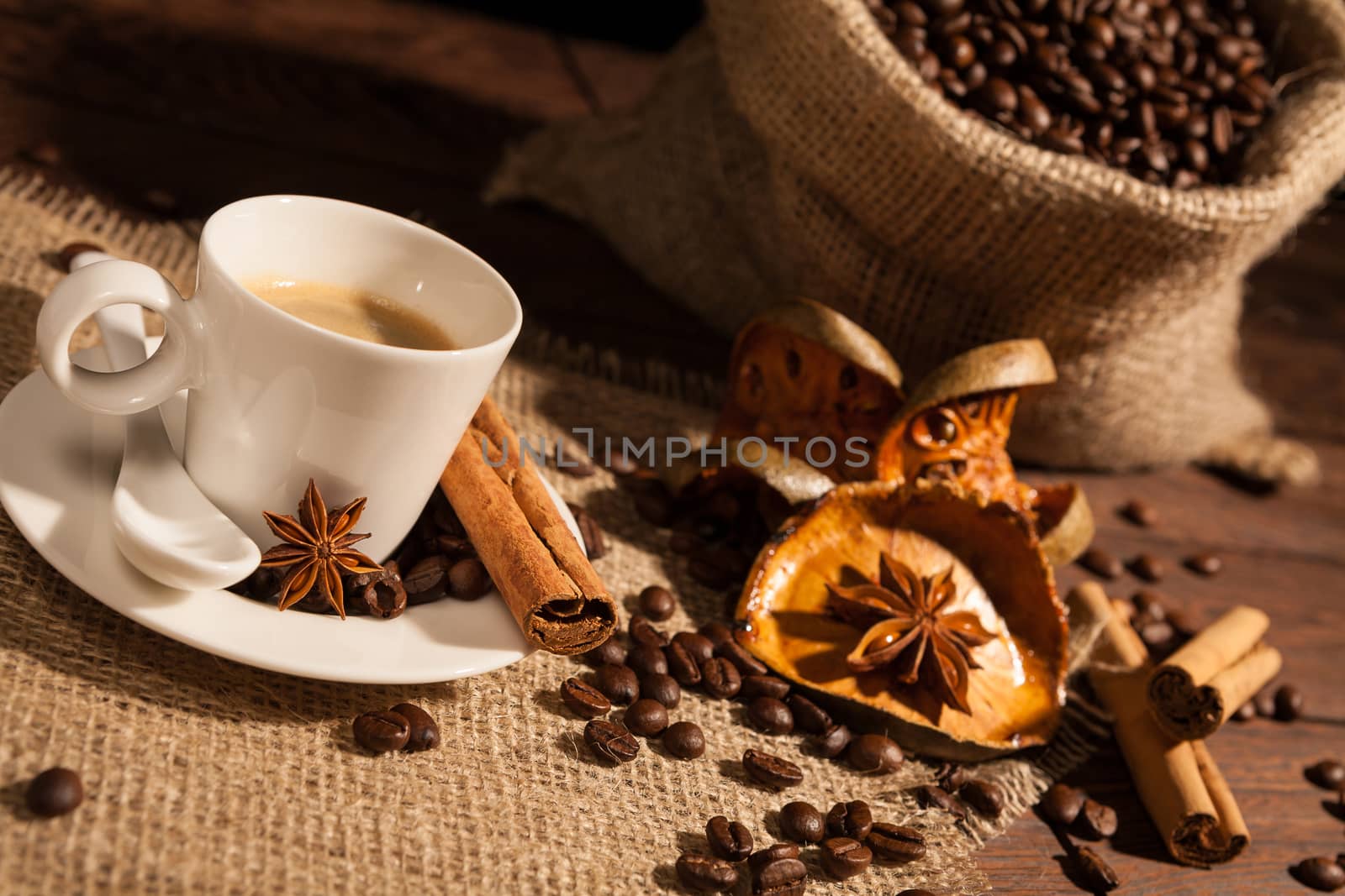 Close-up of coffee cup with star anise, cinnamon and dried orange fruit