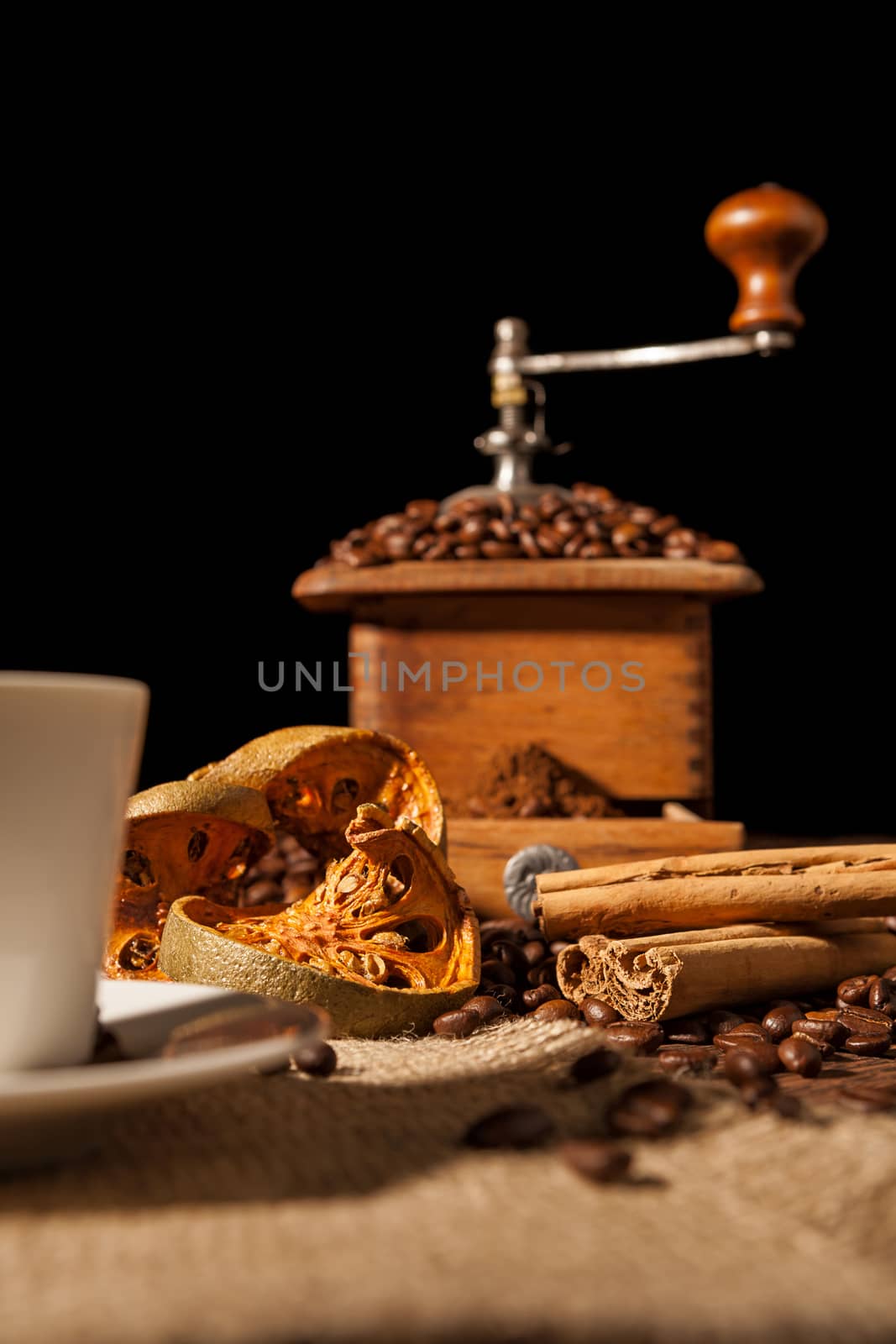 Close-up on dried orange fruit and cinnamon and coffee beans with coffee grinder on background