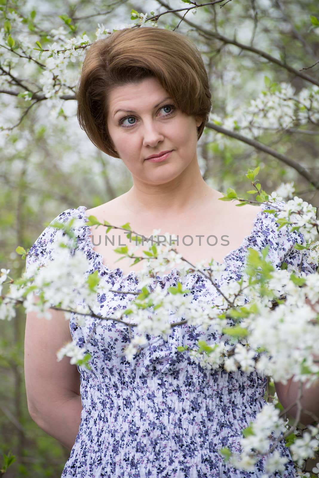  woman in an apple orchard on early spring by olgavolodina