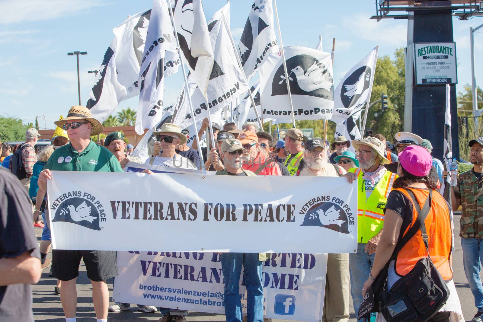 NOGALES, AZ - OCTOBER 08: Large group of men and women from Veterans For Peace holding banners and flags during border policy protest march on October 08, 2016 in Nogales, AZ, USA.