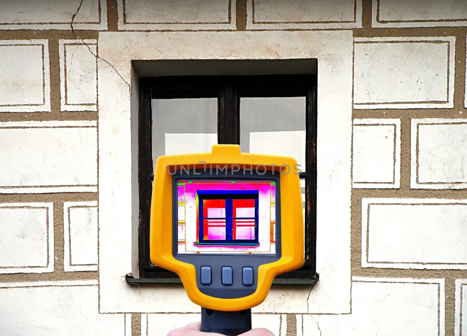 An infrared thermal imager showing building facade and window heat loss.