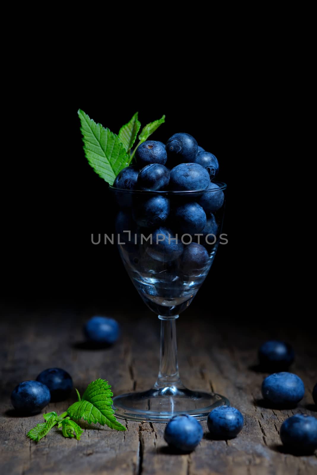 Blueberries with leaves in small glass