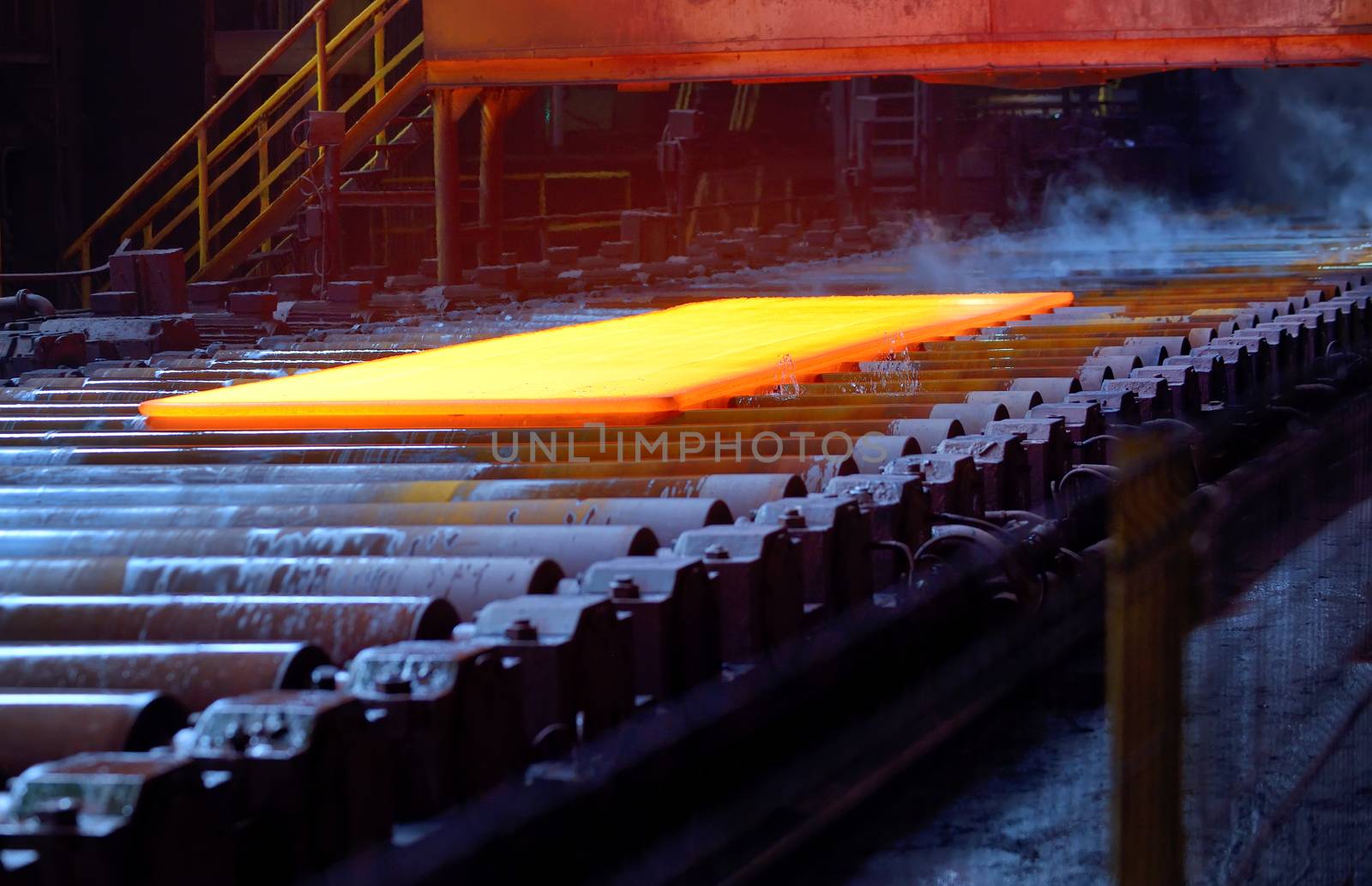 Hot steel plate on conveyor inside of steel plant