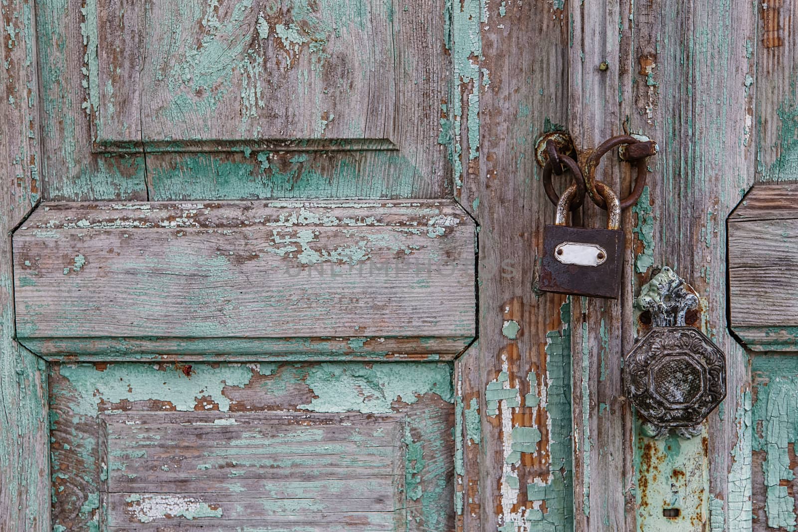 Rusty lock on old door. Cracking and peeling paint on a wall. Vintage wood background with peeling paint. Old board with Irradiated paint