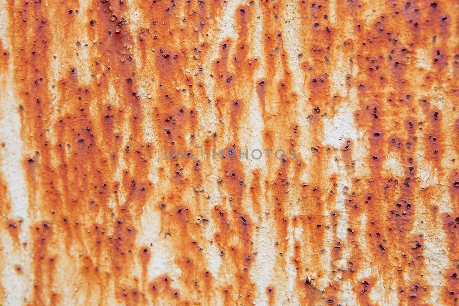 Rusty metal wall background with streaks of rust. Rust stains.