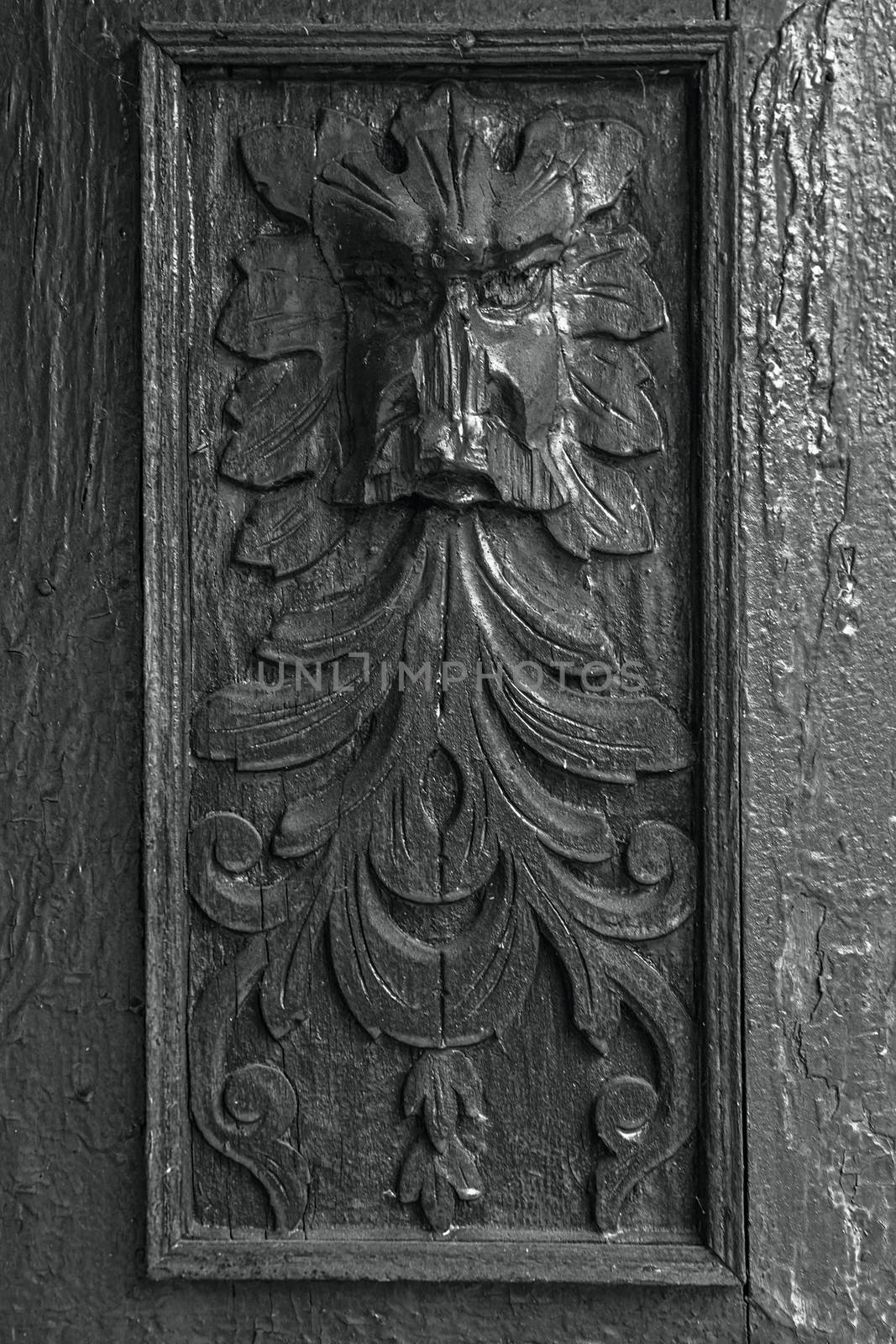 Ancient bas-relief face. Cracking and peeling paint on a wall. Vintage wood background with peeling paint. Old board with Irradiated paint