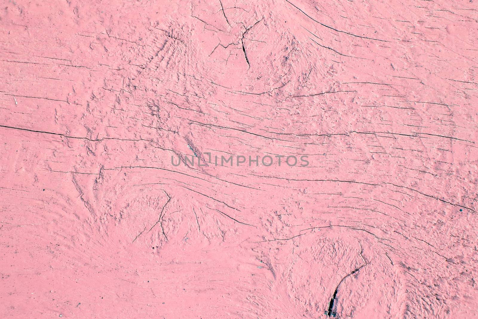 Cracking and peeling pink paint on a wall. Vintage wood background with peeling paint. Old board with Irradiated paint