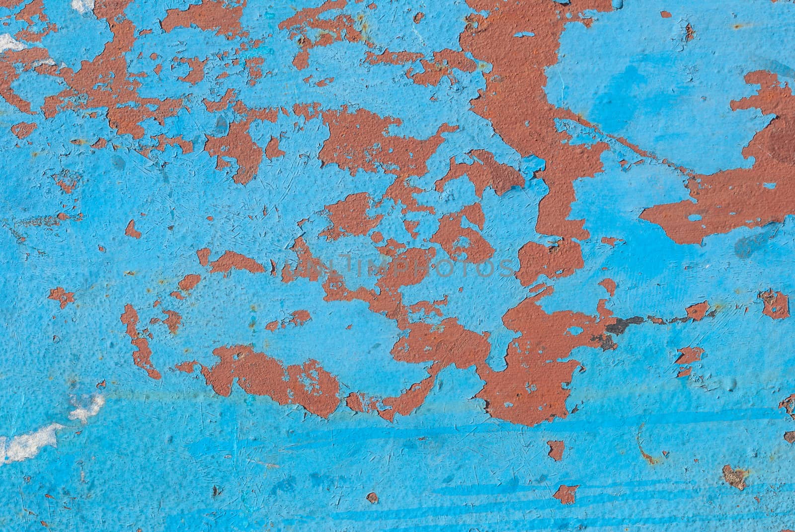 fragment of an iron surface is covered with blue and red color paint, which has long been under the influence of different climatic conditions